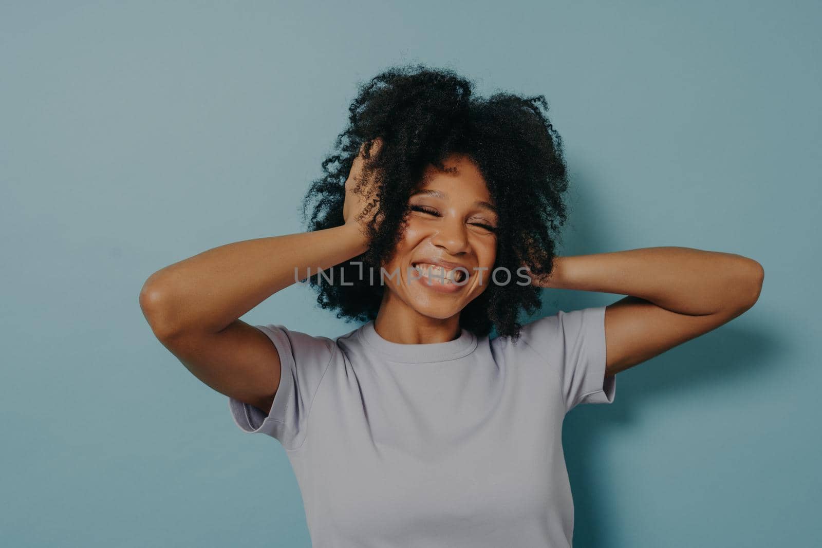 Portrait of happy surprised young woman looking excited in full disbelief with hands on head by vkstock