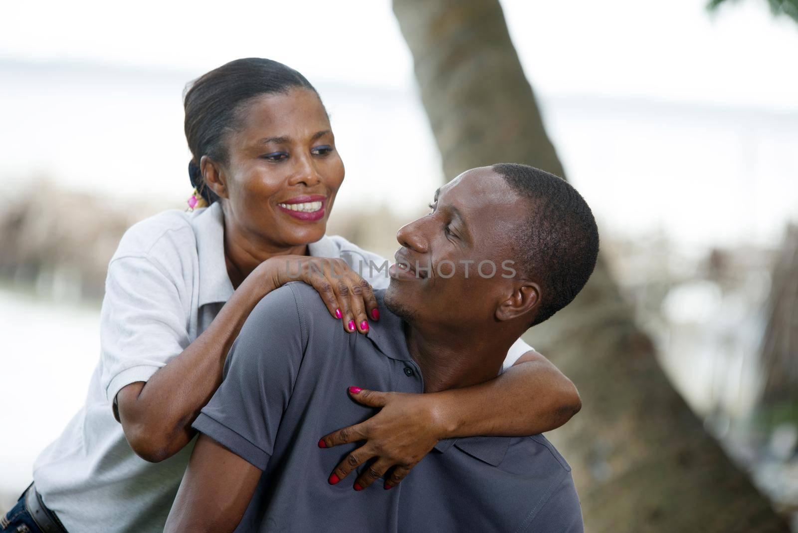 a couple sitting, the woman glued to the man and look at each other with a smile.