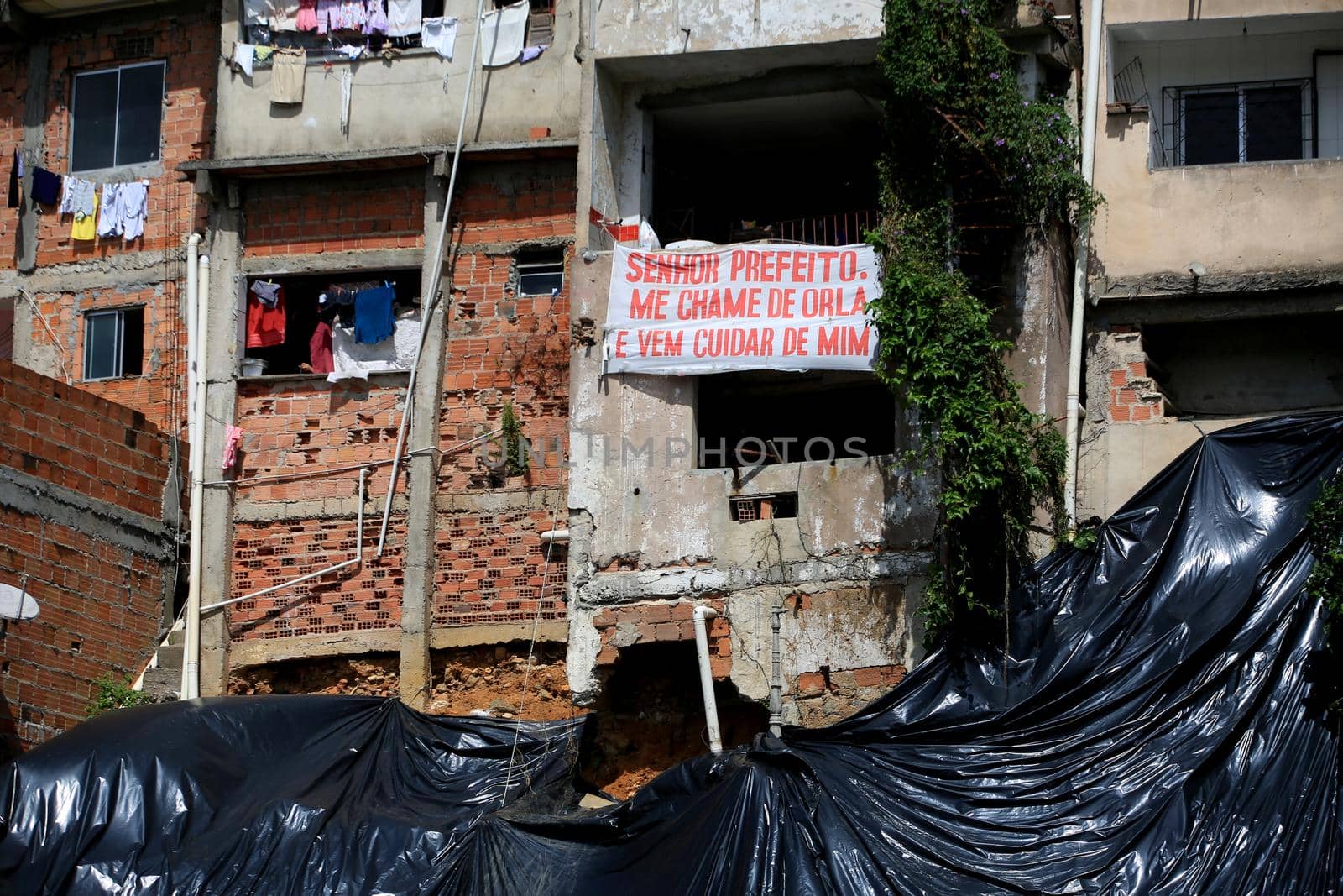 salvador, bahia, brazil - july 24, 2017: Landslide protection canvas is seen next to houses on a slope of a favela in the city of Salvador.