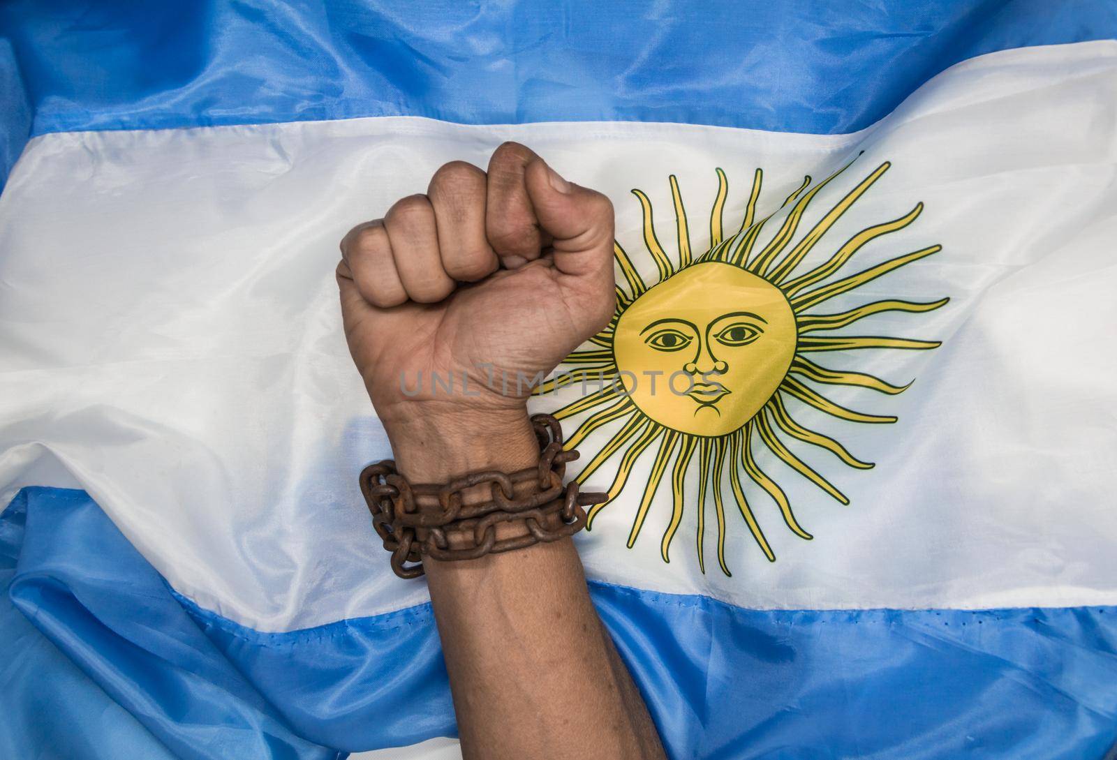 Fists that break the chains on the Argentine flag. Argentine revolution and independence concept by GabrielaBertolini