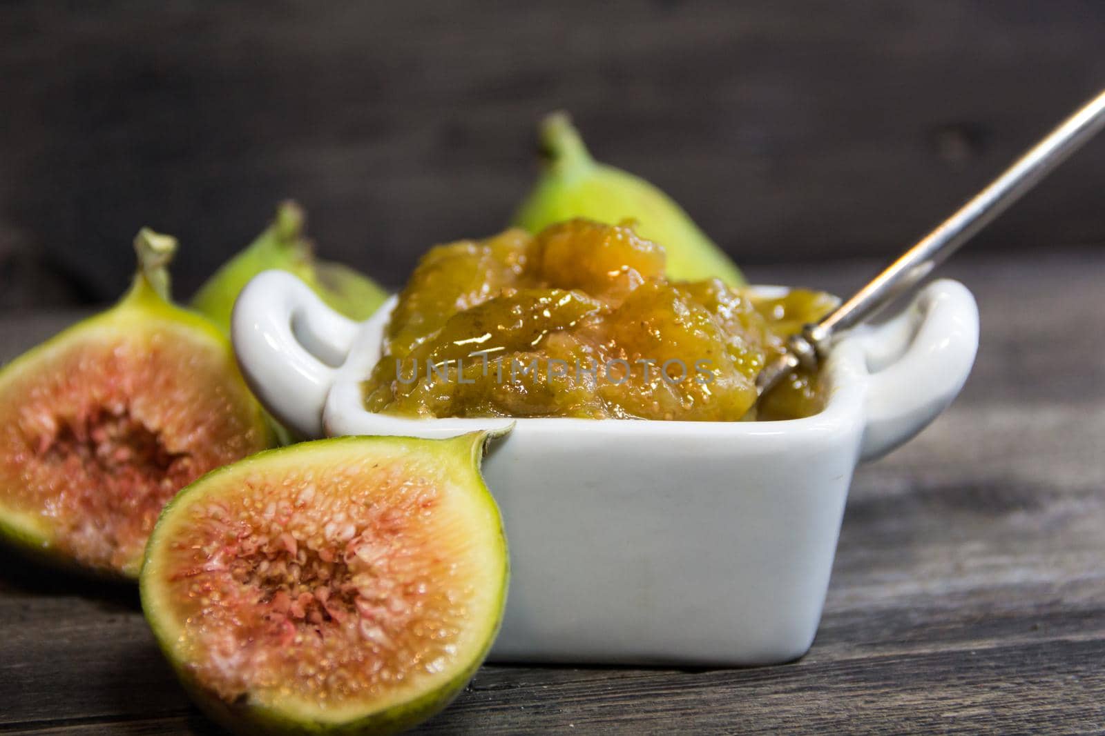 Homemade sweet of green figs. fig jam on rustic wooden background by GabrielaBertolini