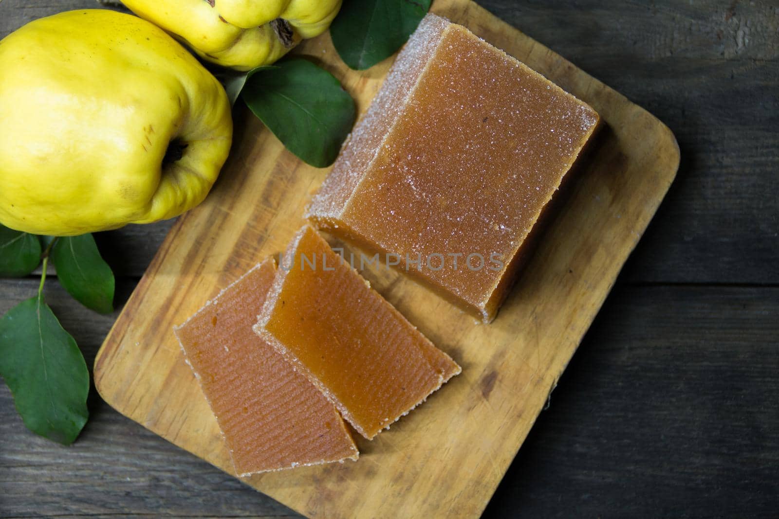 quince jelly and quinces on rustic wooden background