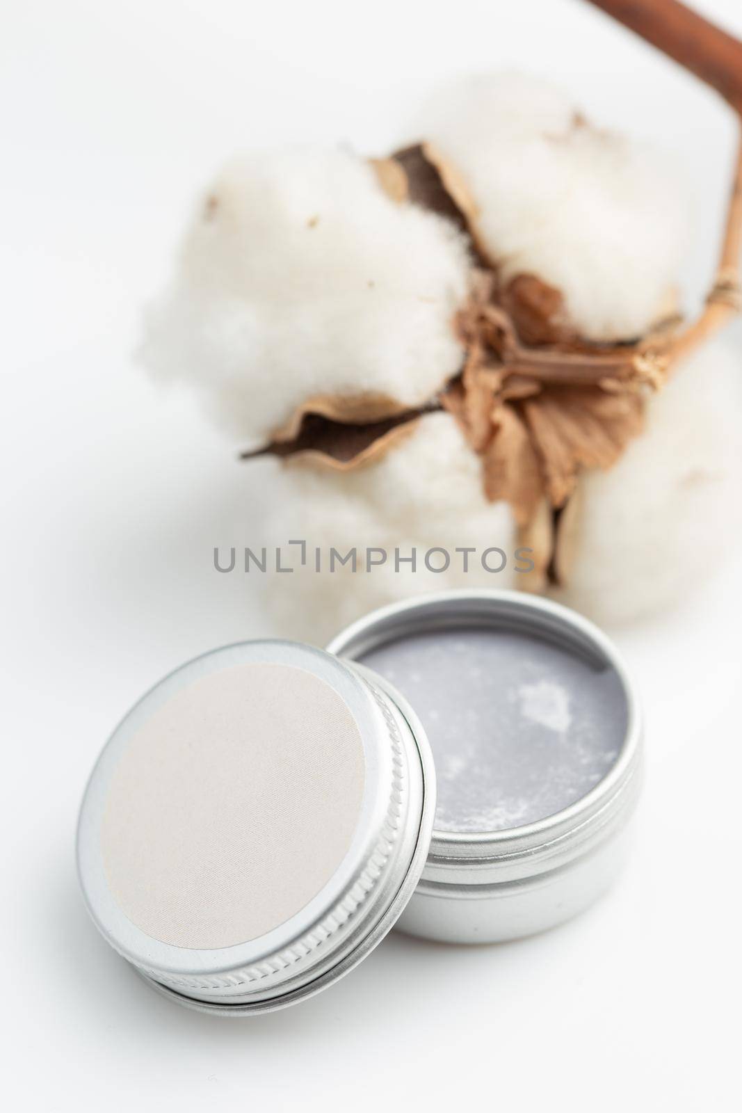 Gray metal cosmetic jar with beauty product on white background