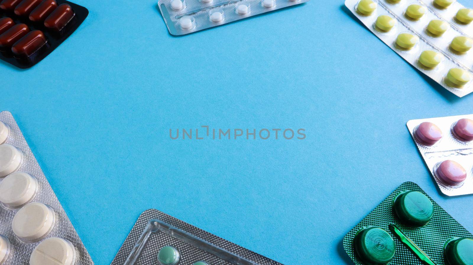 colored medicines and pills in packs on a blue background. Copy space. Pharmacology and medicine are fighting for health. Treatment of various diseases