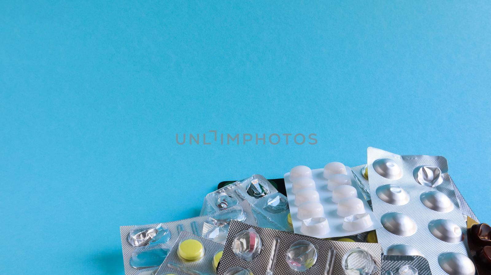 Pills, capsules with medicine, vitamins in the package, in blister packs are on the table. antibiotics, multicolor antibacterial drugs. Healthcare and medicine concept. Copy space