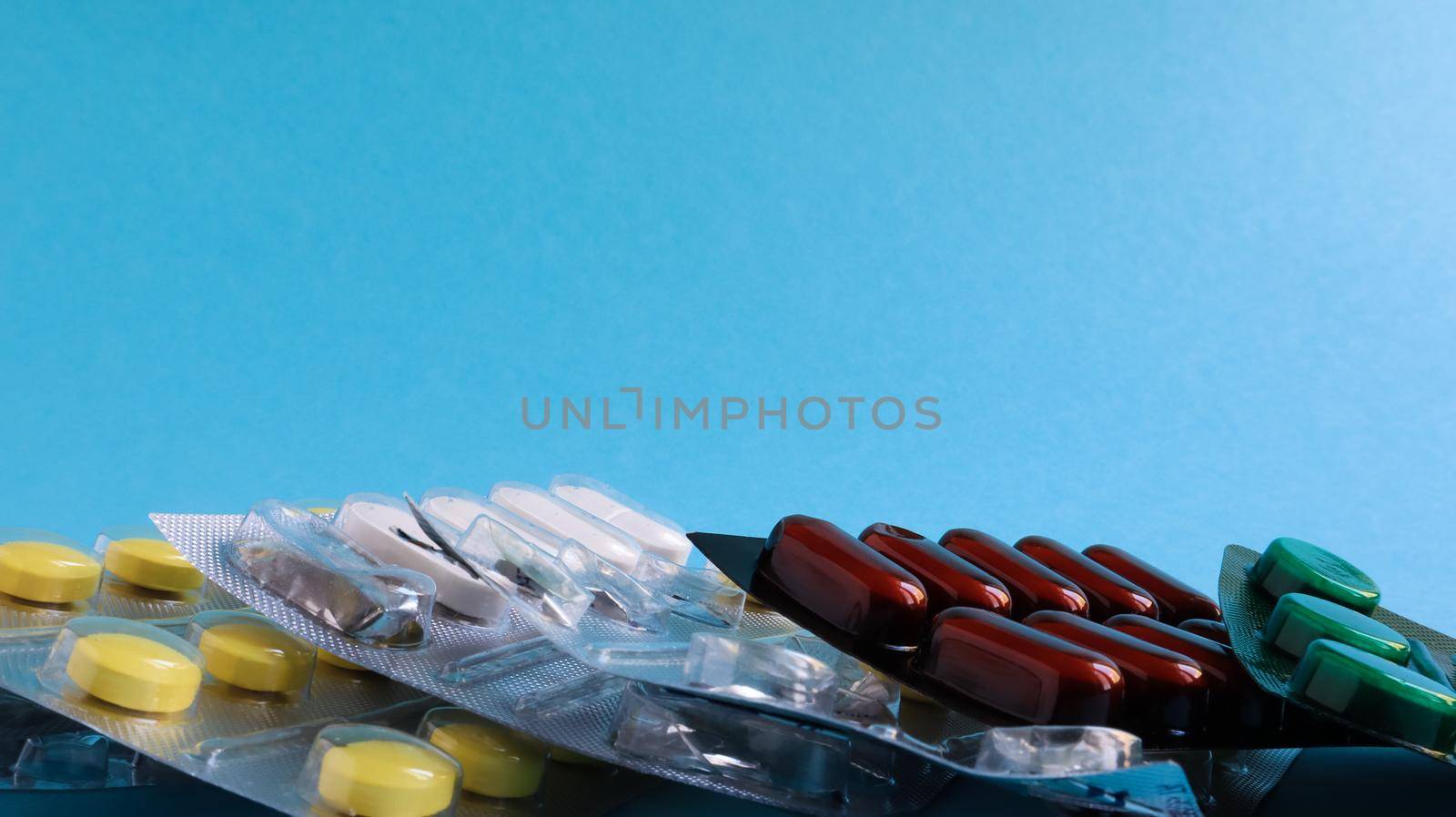 Pills, capsules with medicine, vitamins in the package, in blister packs are on the table. antibiotics, multicolor antibacterial drugs. Healthcare and medicine concept. Copy space