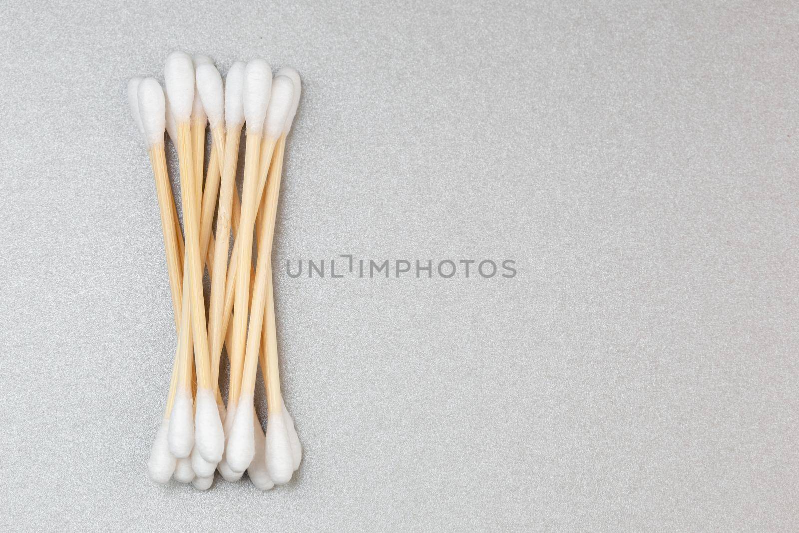 Bamboo cotton ear swabs on grey background with copy space. Sustainable hygienic accessory product concept.