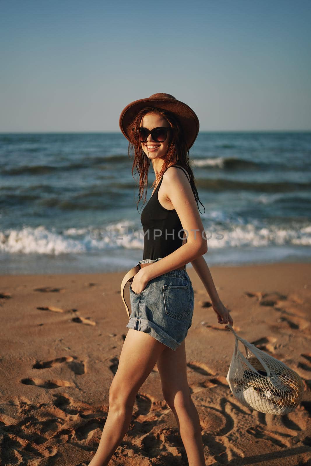 pretty woman in hat walking on the beach ocean travel by Vichizh