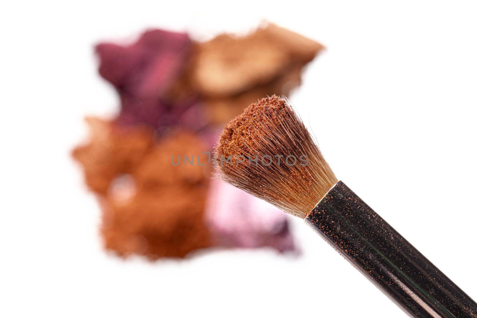 Crushed eyeshadow samples of bright colors isolated on white background