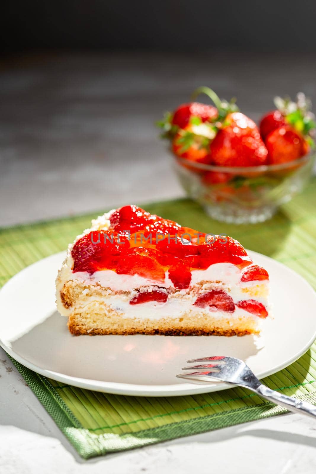 A piece of strawberry cake served on a white plate redy to eat
