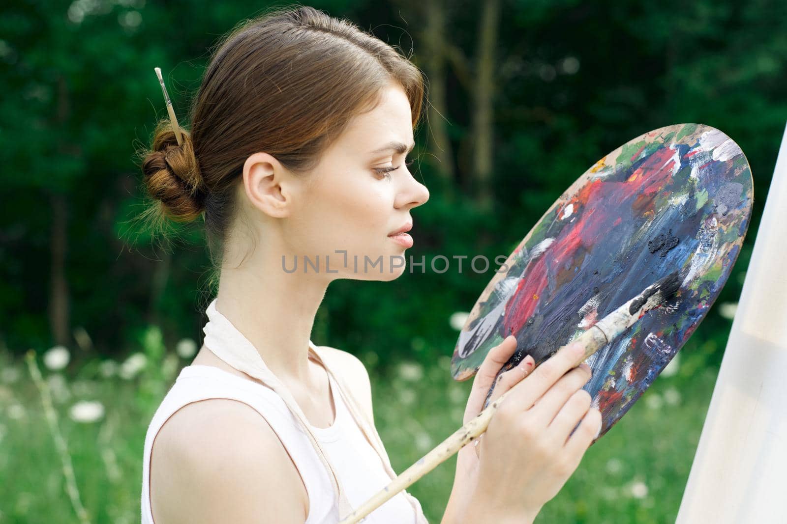 woman artist nature paints palette easel creative landscape. High quality photo