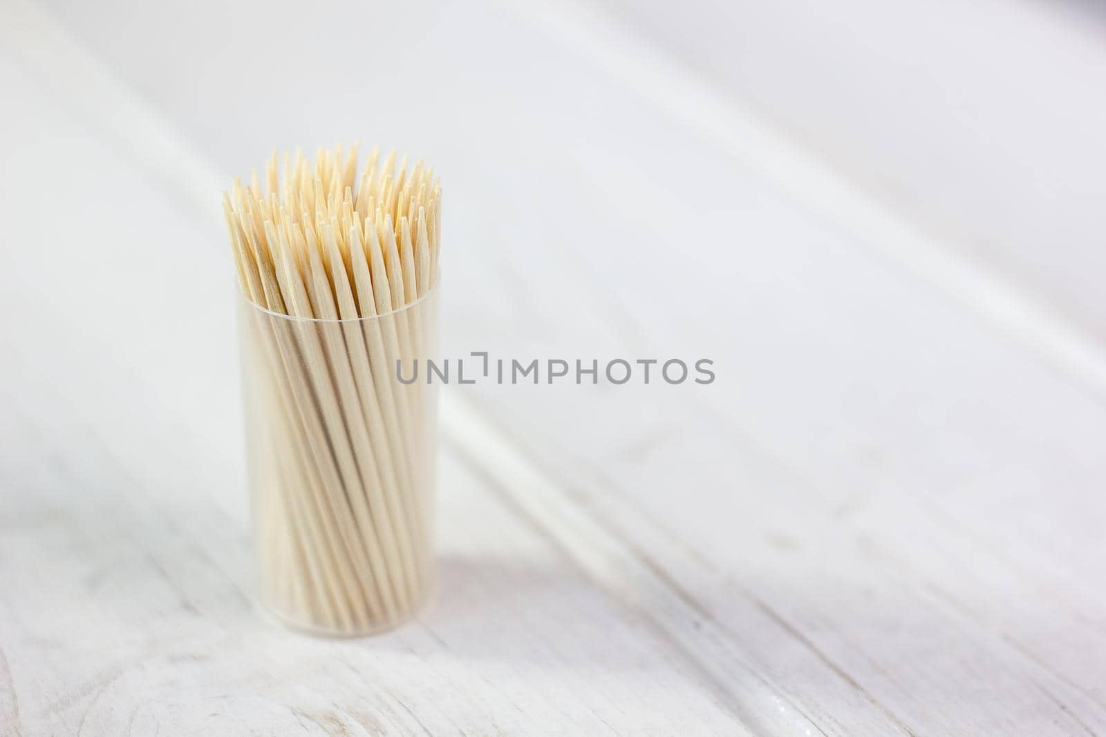 Bamboo toothstick in a case over the white table. Great photo for your needs.