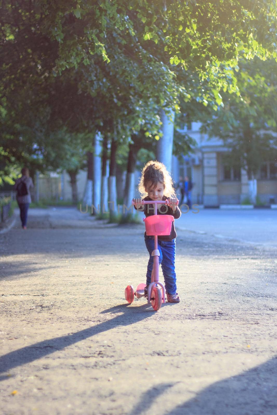 Yong kid girl ride on street with child scooter by sharafizdushanbe