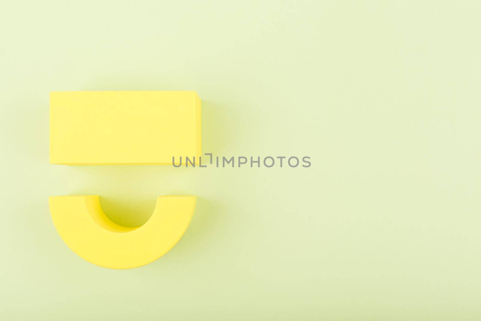 Creative flat lay with yellow happy smile symbol made of figures on bright green background with copy space. Concept of Smile day, emotions, emoji or mental health
