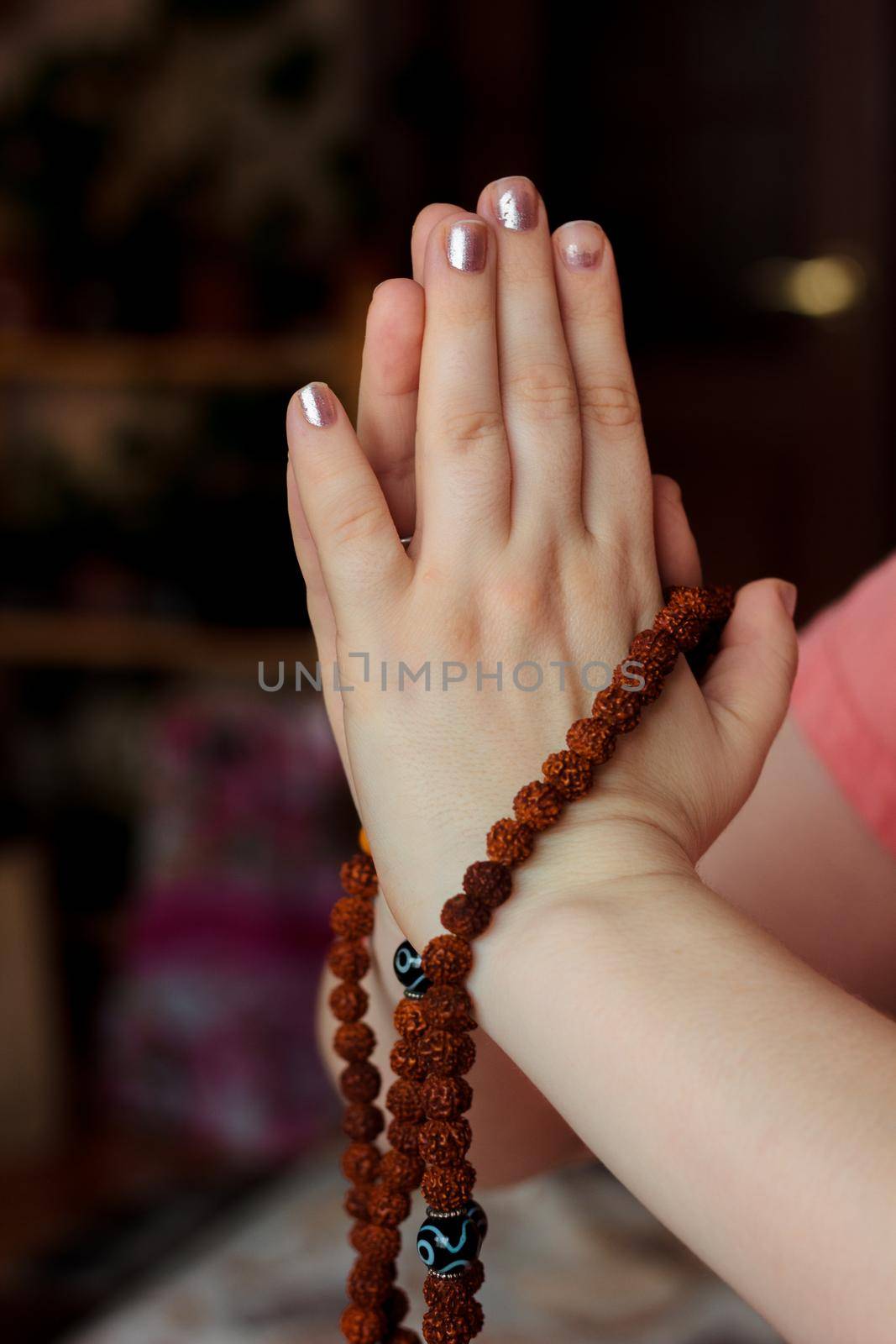 Woman hands holding rudraksha rosary with the namaste mudra
