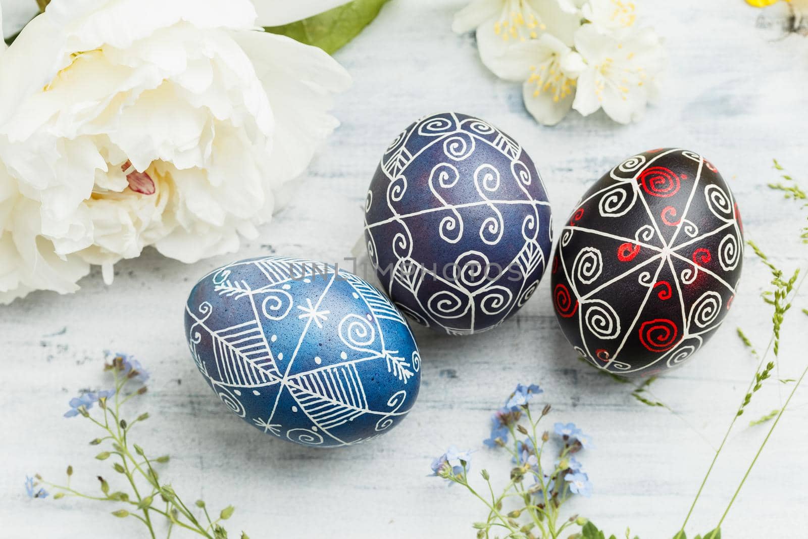 Three pysanky handmade Easter eggs. Ukrainian pysanky decorated with wax-resist dyeing technique. Holiday postcard
