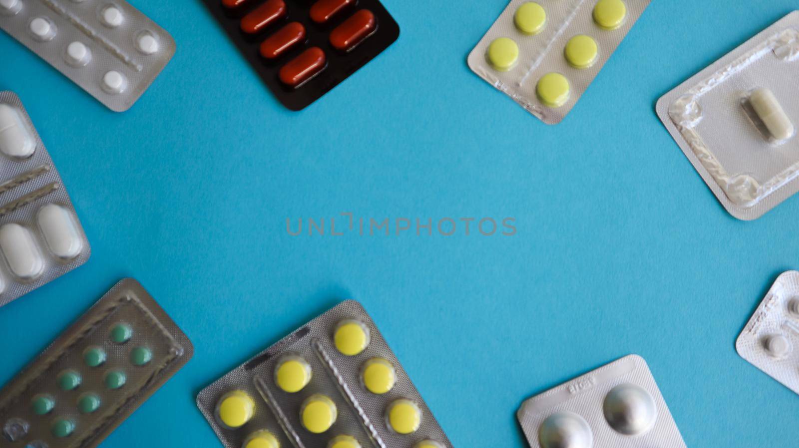 colored medicines and pills in packs on a blue background. Copy space. Pharmacology and medicine are fighting for health. Treatment of various diseases