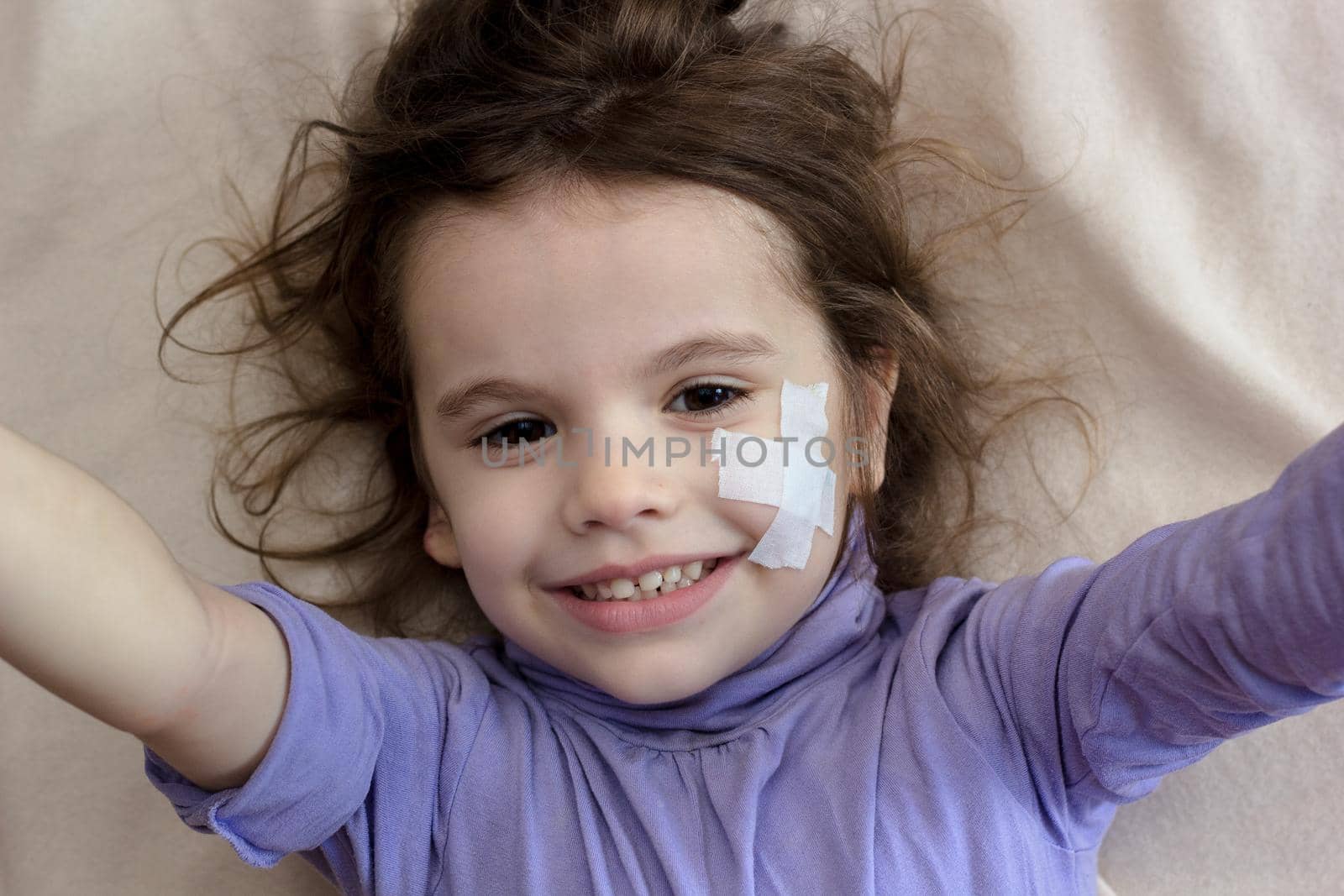 Little kid girl with adhesive band on face making selfie