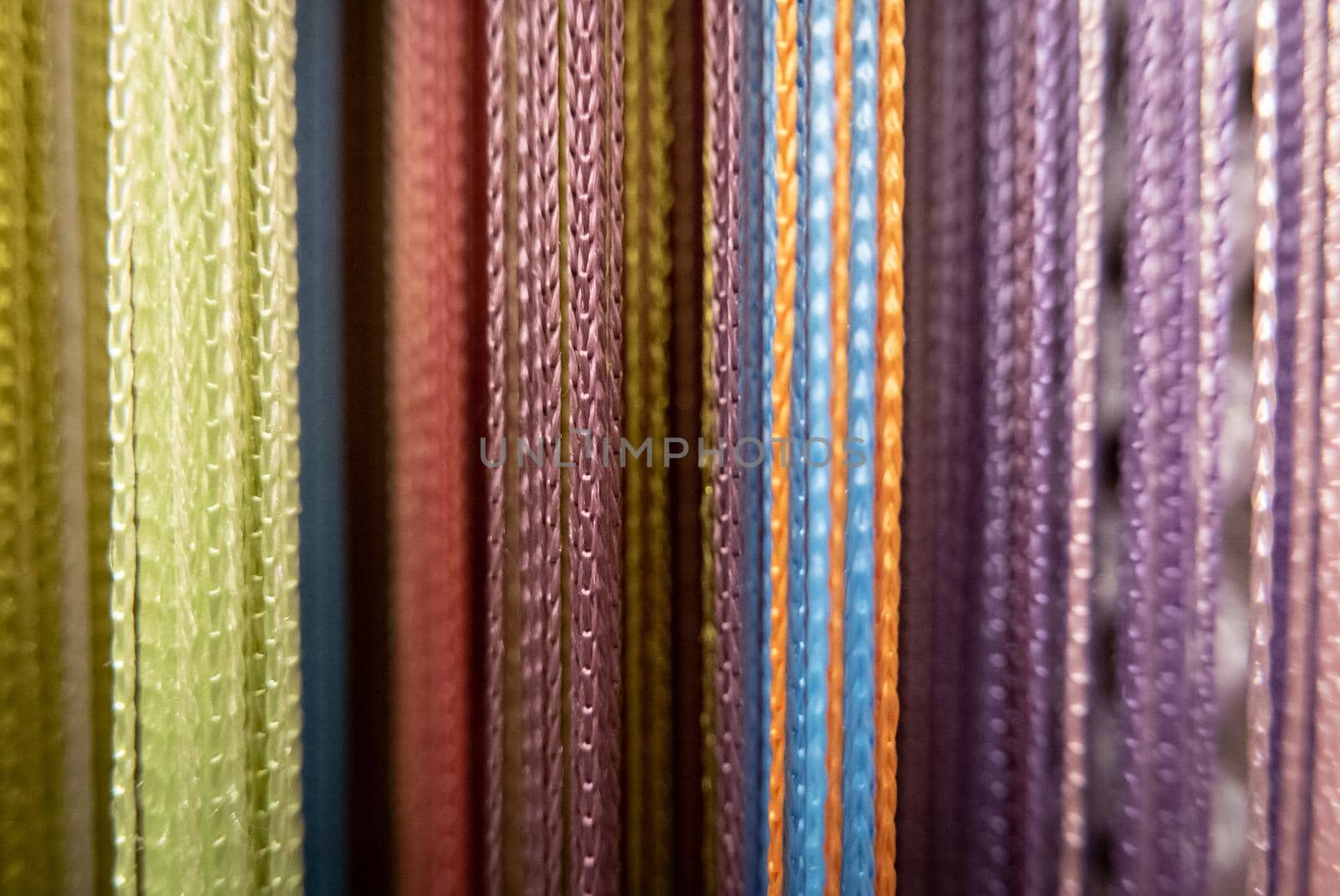 Textile strings and ropes hangs in a fabric shop. Abstract background