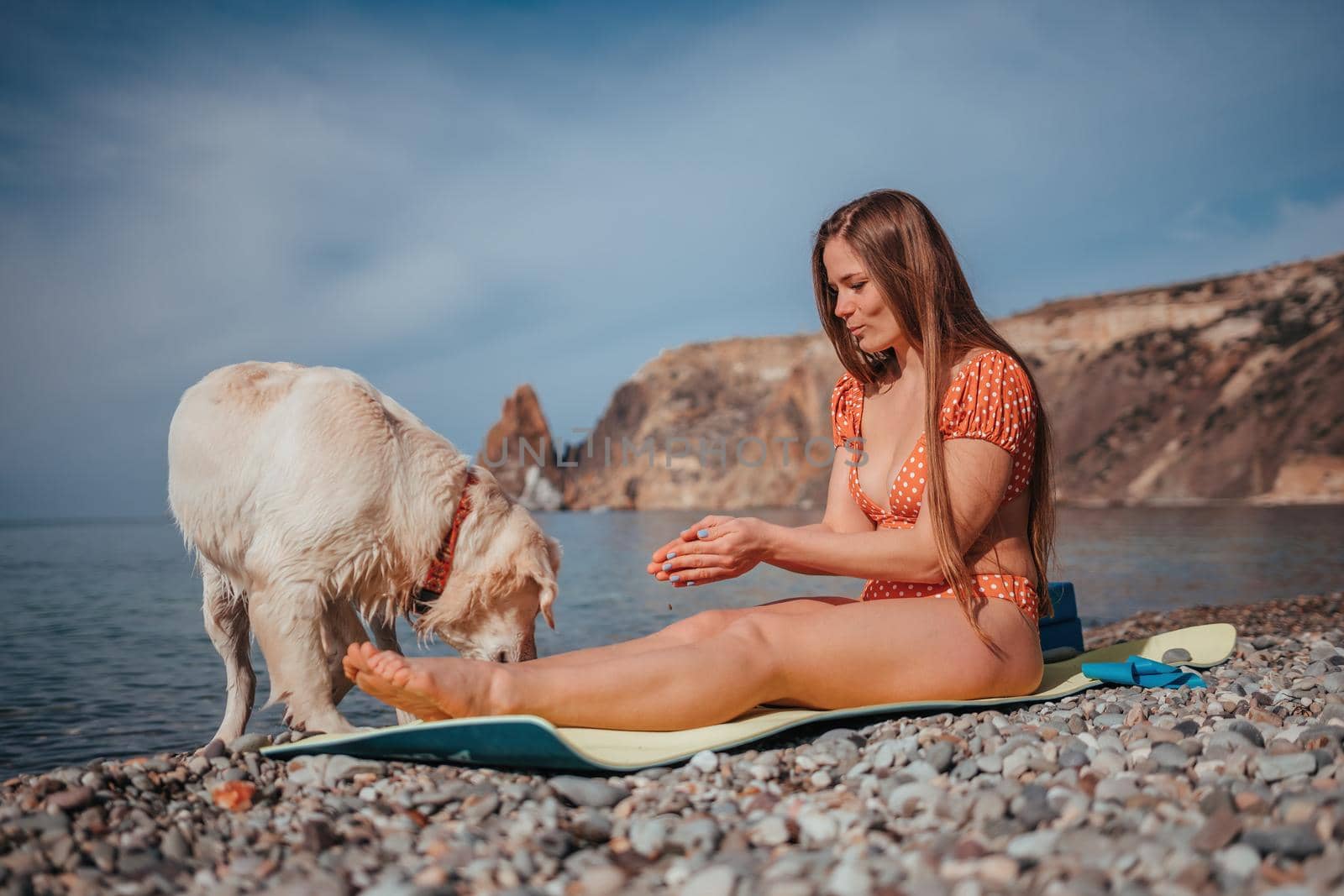 Young woman in swimsuit with long hair practicing stretching outdoors on yoga mat by the sea on a sunny day. Women's yoga fitness pilates routine. Healthy lifestyle, harmony and meditation concept by panophotograph