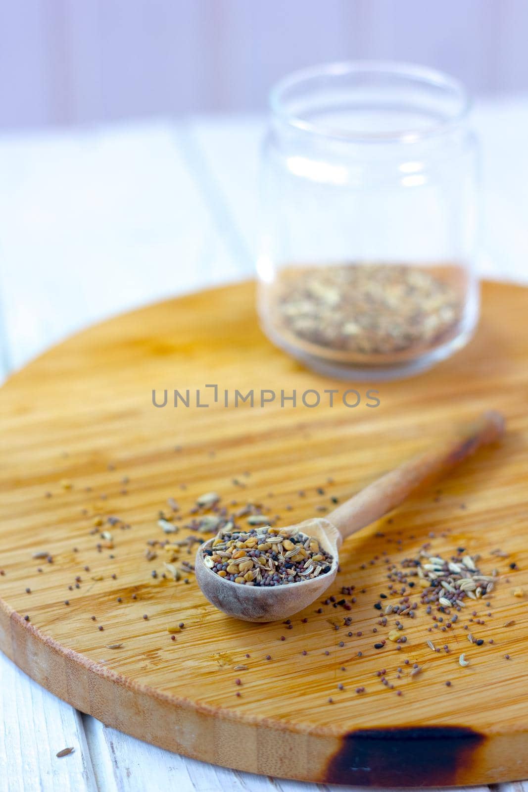 Spice mix inside the wooden spoon on a table