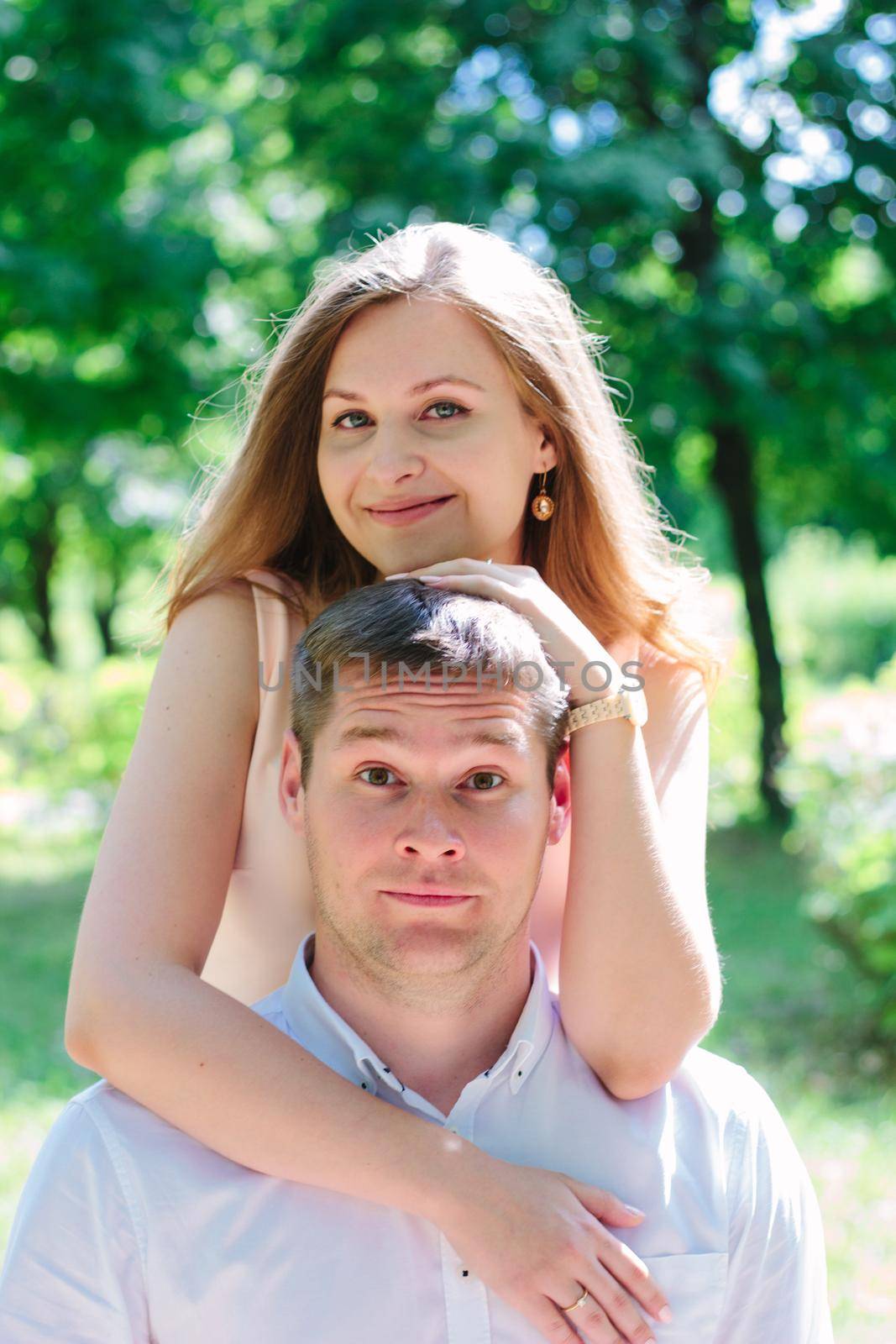 Young couple - girl huggs guy from back and smiling by sharafizdushanbe