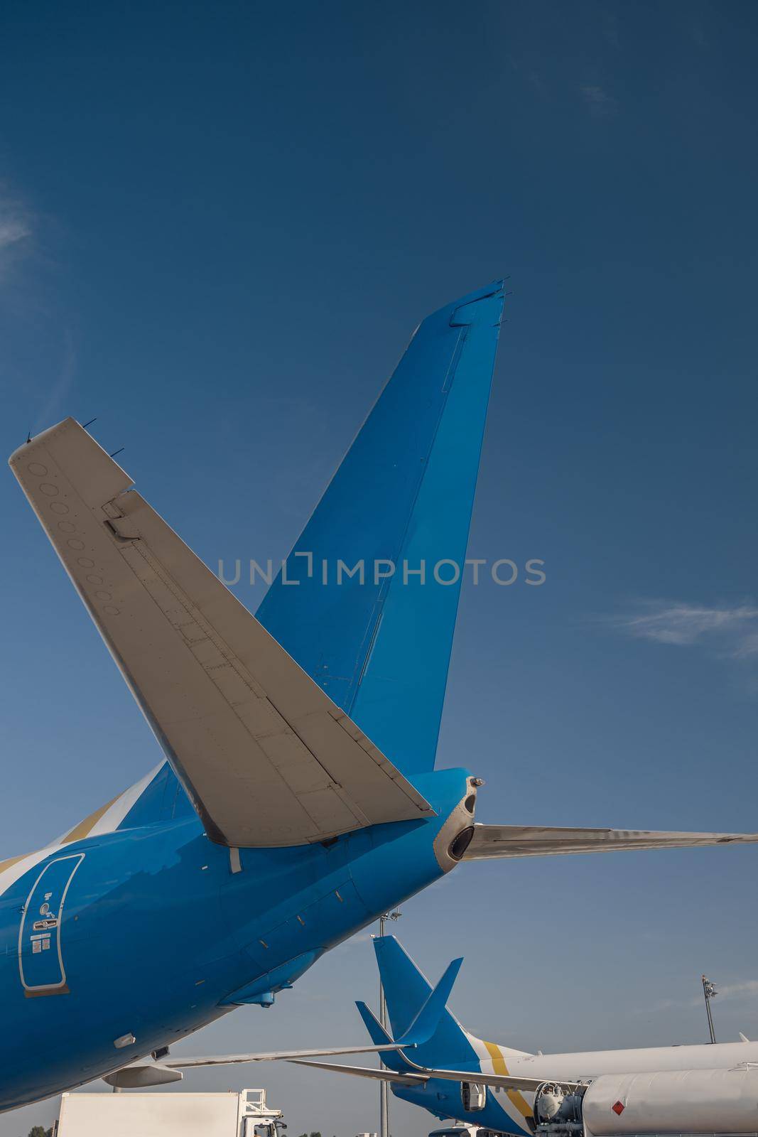 Aircraft tail of international airlines in airport with blue sky in the background. Plane, transportation concept