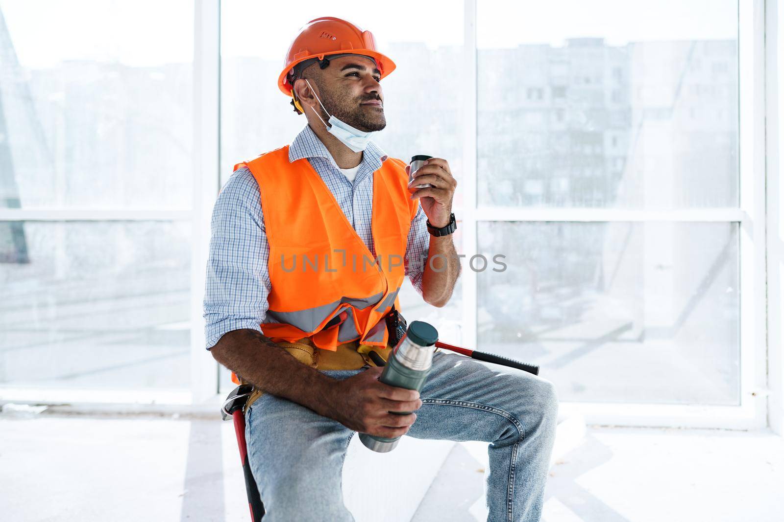 Portrait of a man worker in workwear on a break drink coffee and have rest, close up