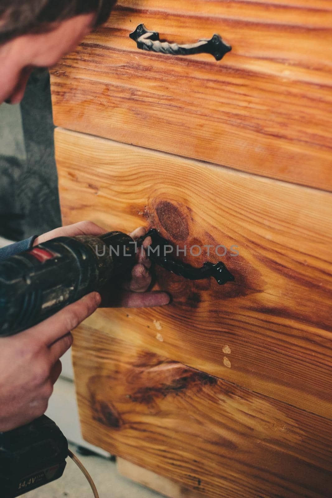 Carpenter mount the knob to wooden door. Great photo for your needs.