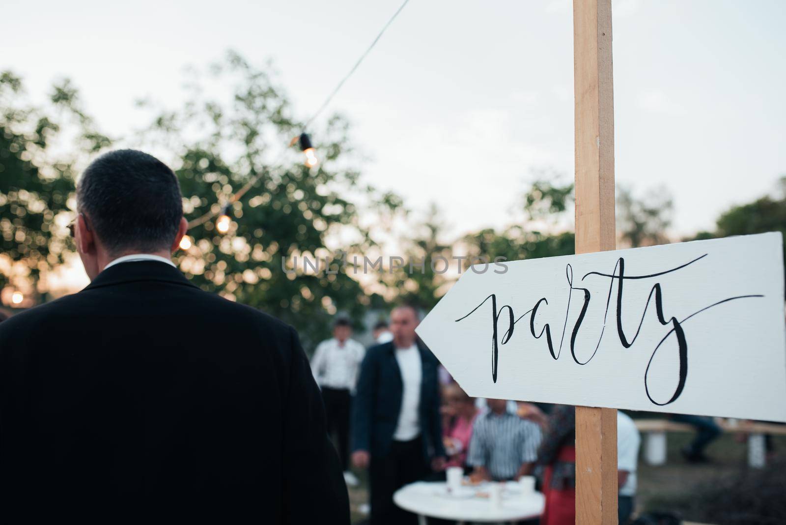 Group of people on nature and pointing arrow with text party.