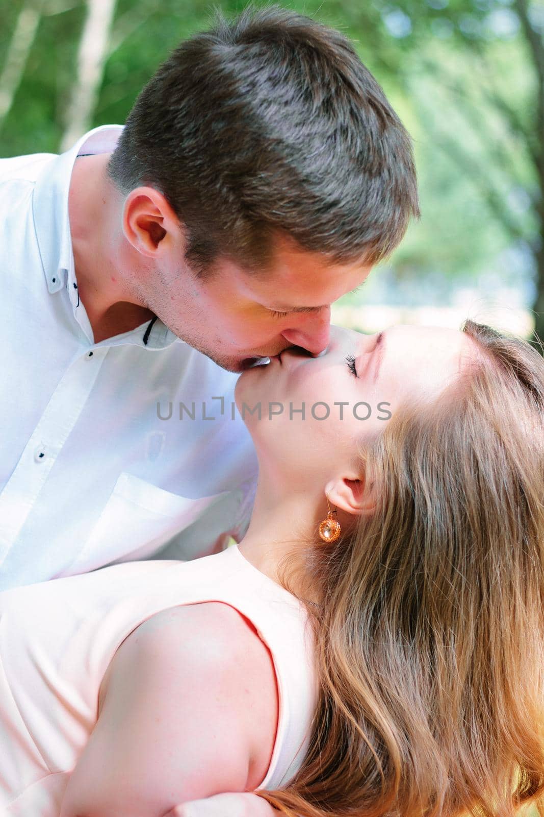 Young couple - girl and guy kissing at the park