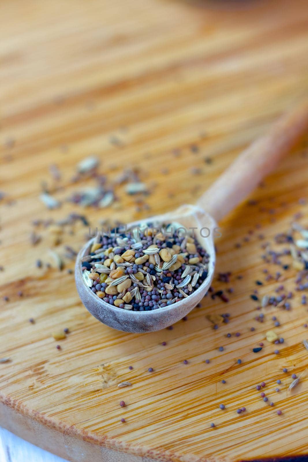 Spice mix inside the wooden spoon on a table