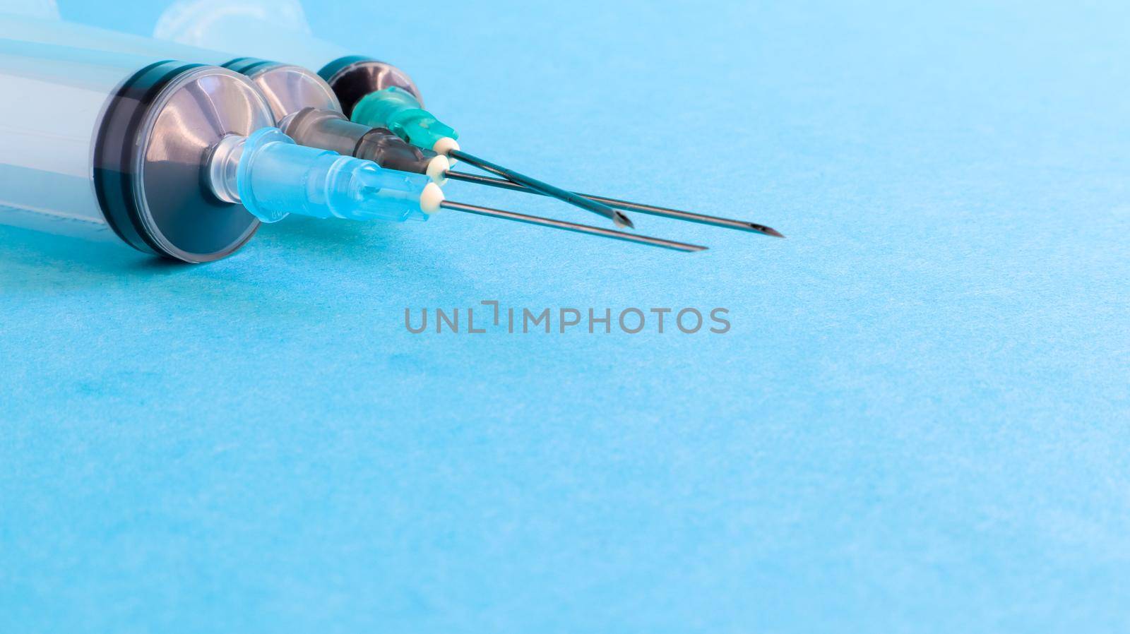 Three medical disposable plastic empty syringes with needles of different sizes and volumes. Vaccination concept, quarantine, self isolation, protection against coronavirus, medicine. copy space.