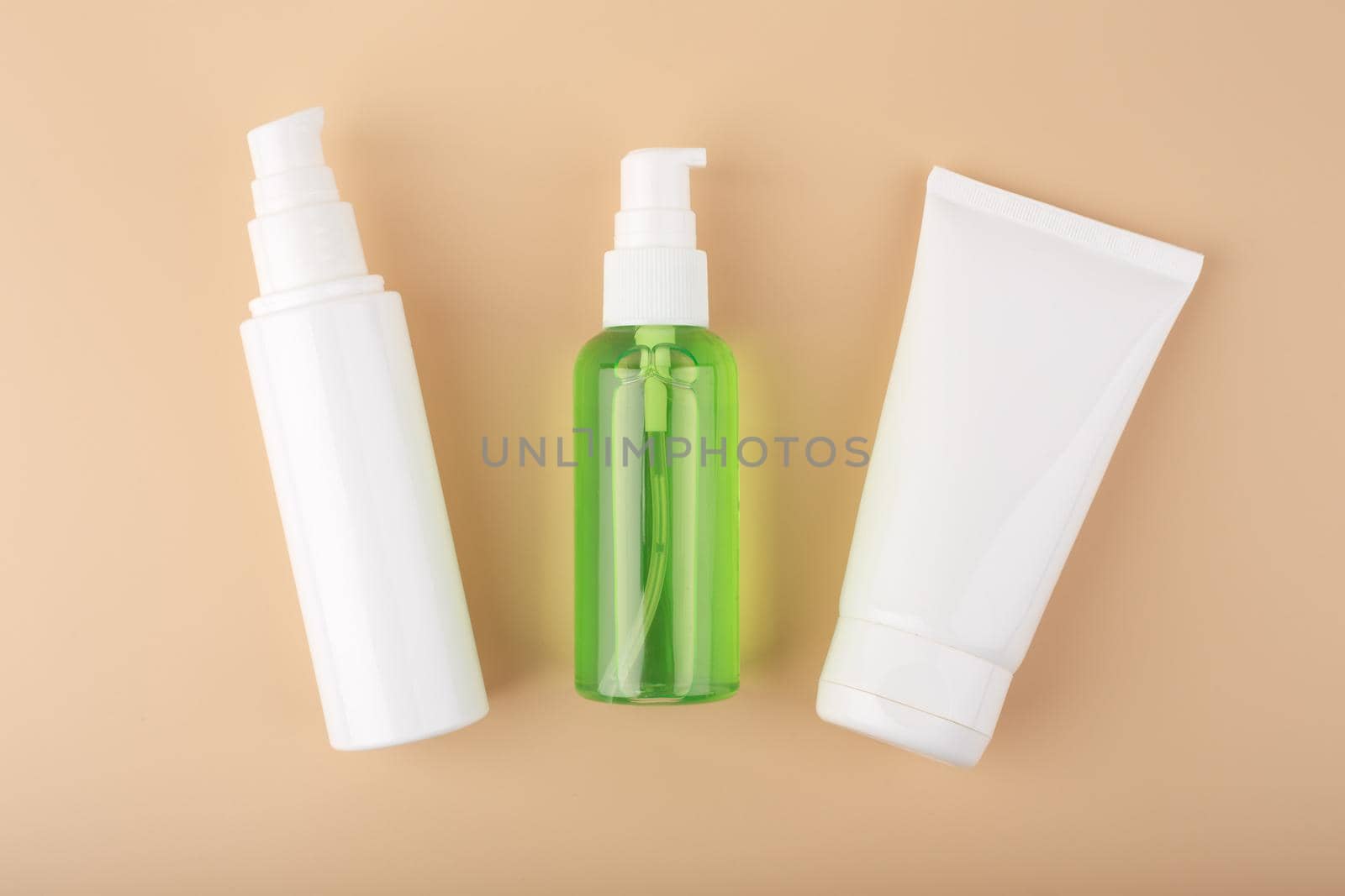 Cosmetic products for daily skin care in white unbranded tubes on pastel beige background by Senorina_Irina