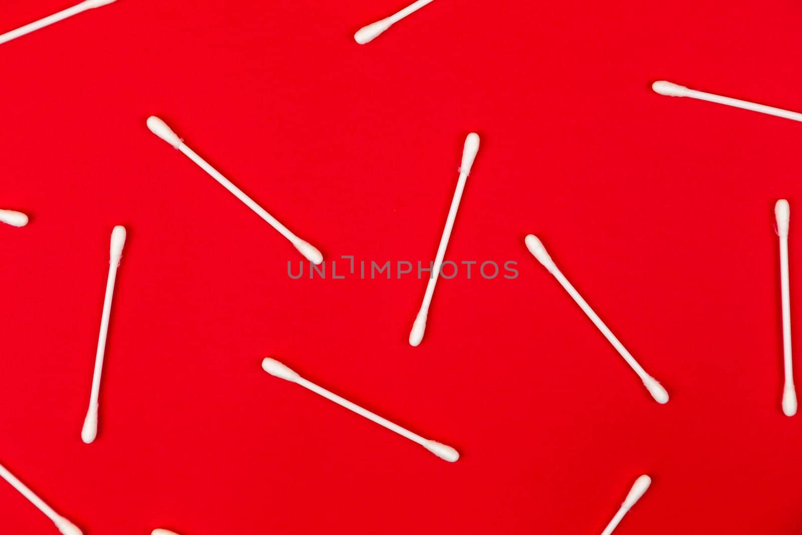 Flat lay composition with cotton swabs on red background. Top view ear sticks by lunarts