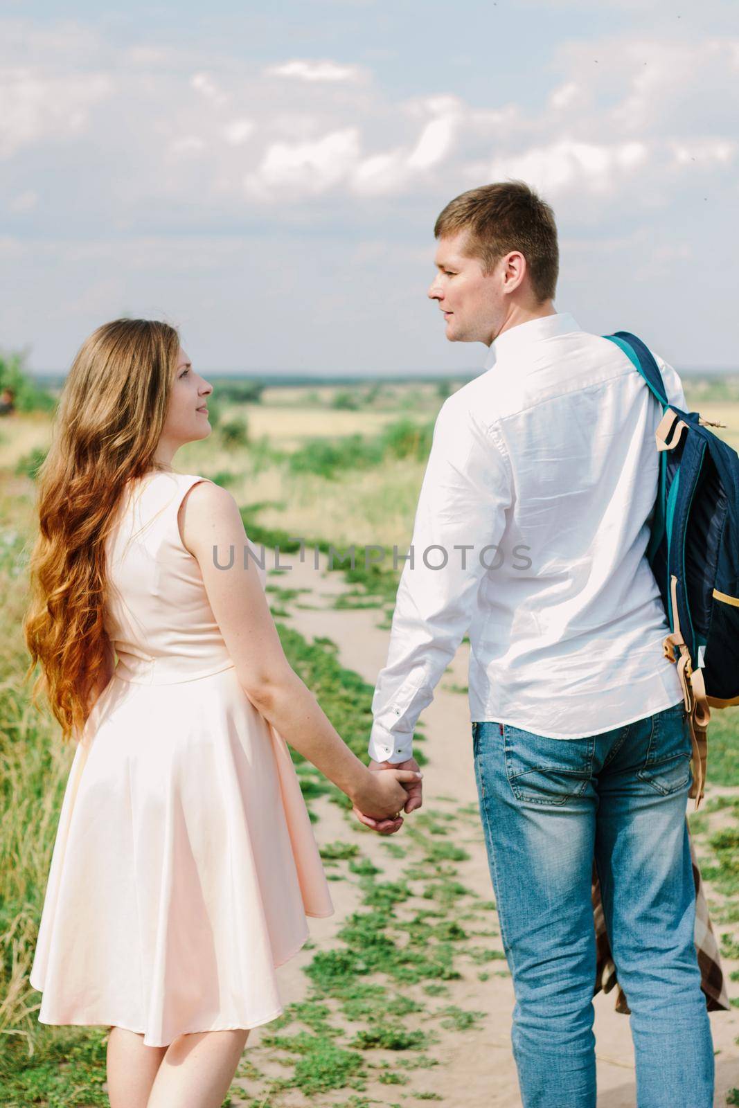 Back view of young couple walking on the nature