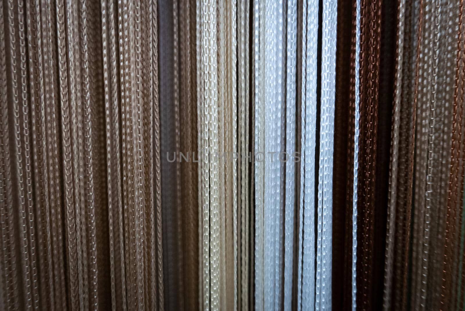 Textile strings and ropes hangs in a fabric shop. Abstract background
