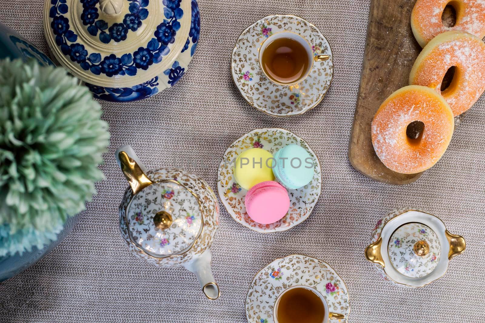 Traditional table with cup of tea and tea pot and colorful macaron lovely cozy table at home,Mother's Day tea setting with teapot, close up