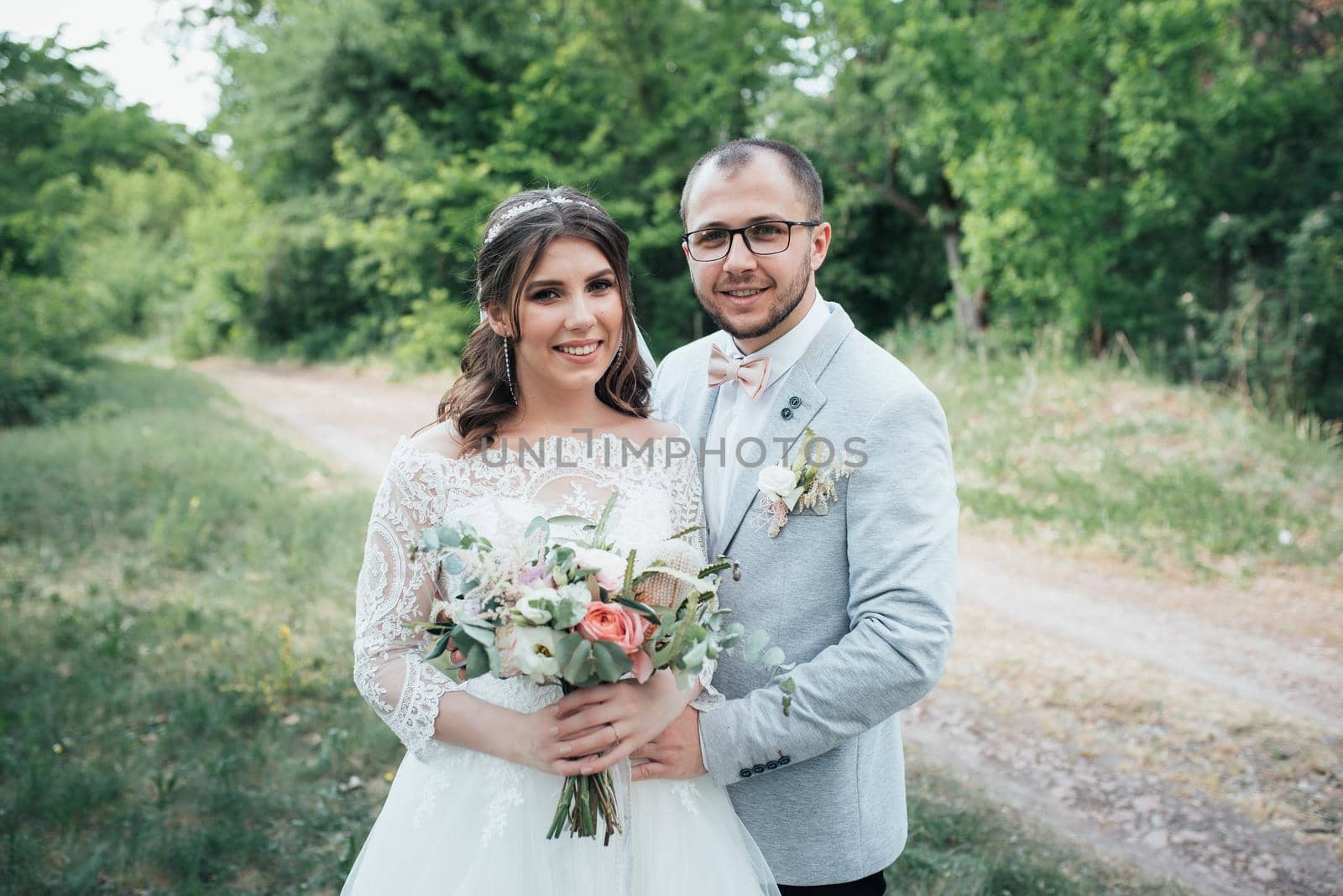 Wedding photo of the bride and groom in a gray-pink color on nature in the forest and rocks