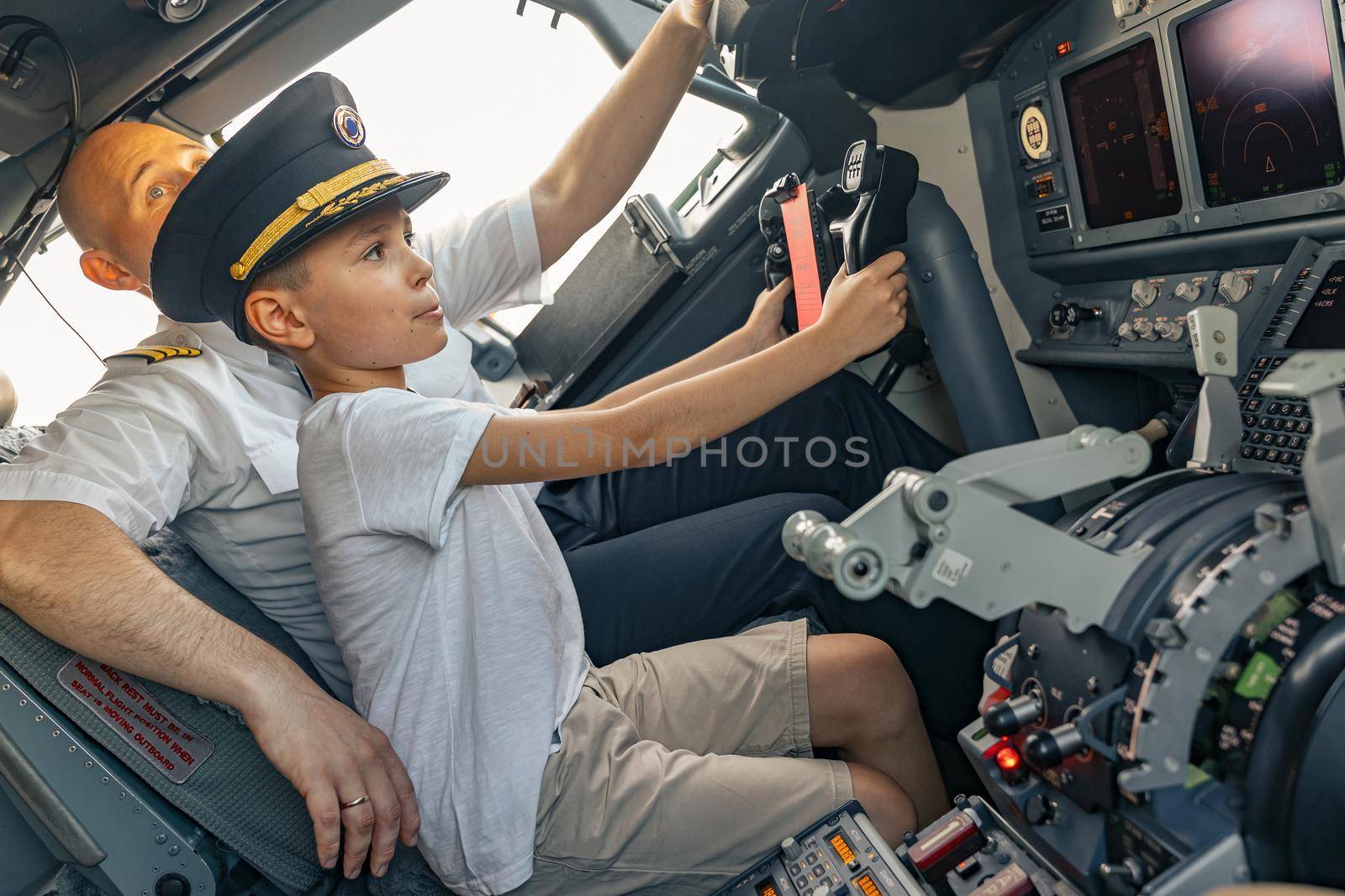 Little boy in a pilot cap in the cockpit by Yaroslav_astakhov