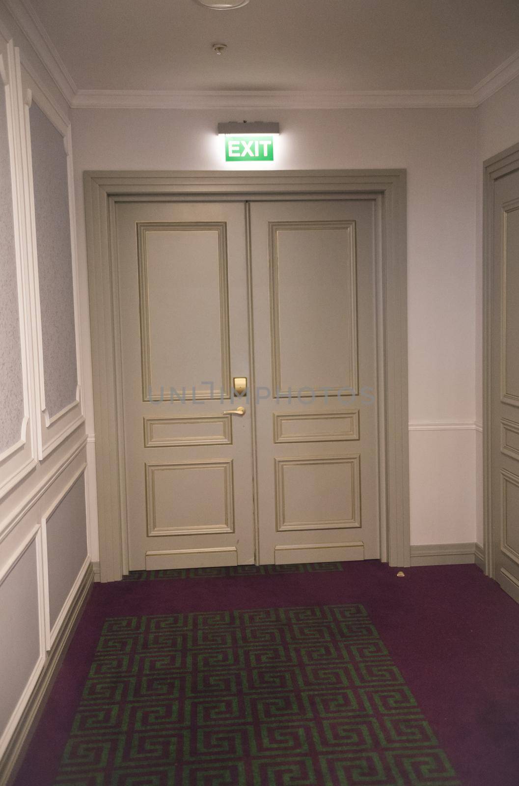 Emergency exit door in a restaurant with a neon sign. Mid view