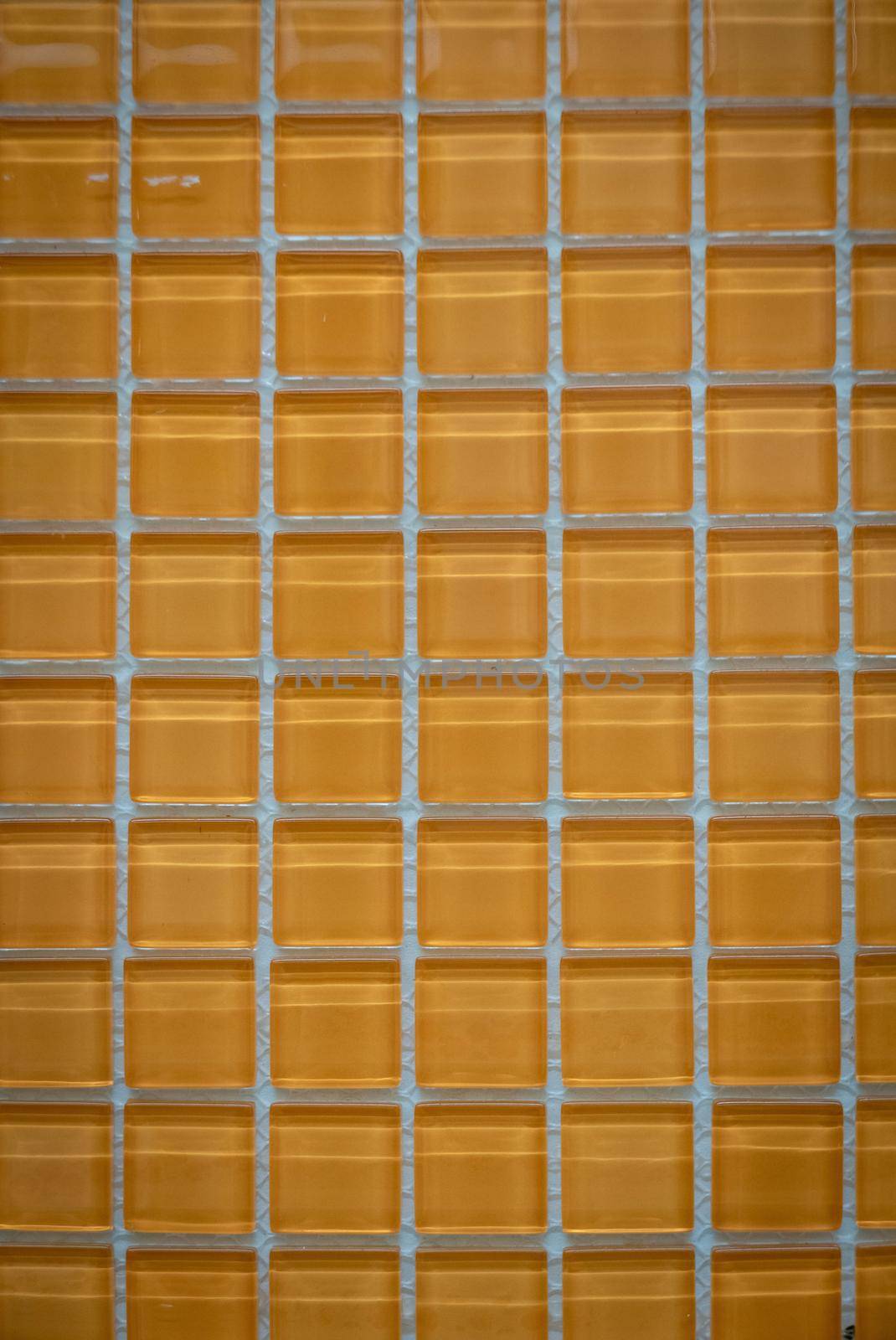 Yellow ceramic mosaic on the wall as background.