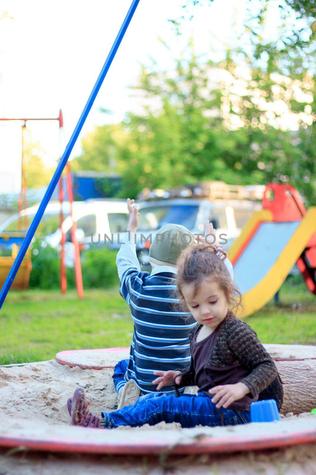 Little kid girl playing with the sand on the playground