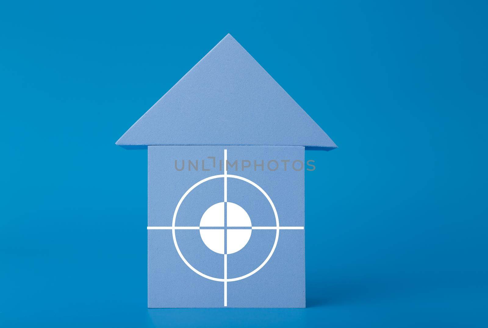 Mortgage, loan or saving money for home and investing in real estate trendy concept. Blue toy house with white target in the middle against blue background with copy space