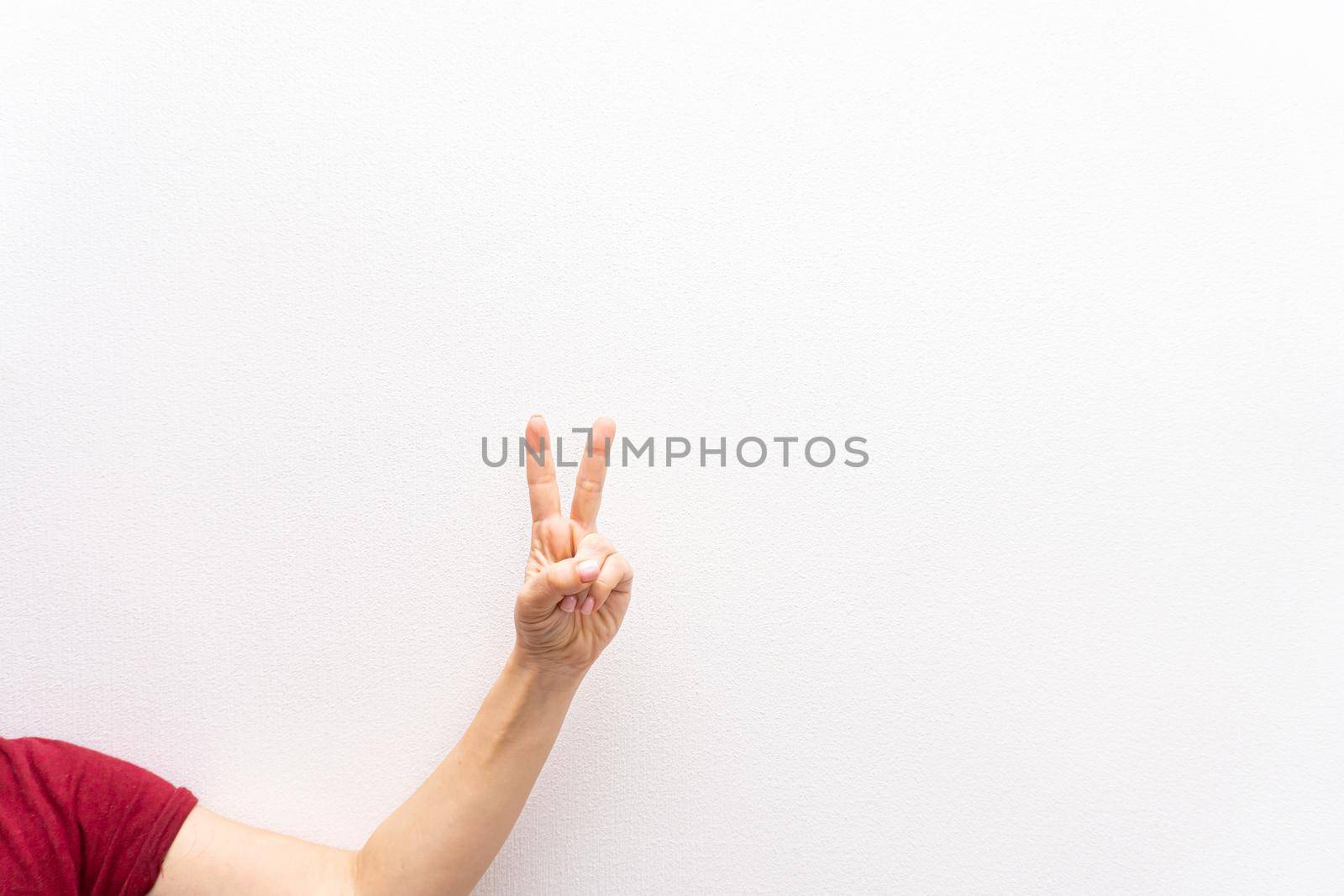 girl makes peace gesture or victory gesture with two fingers, by uveita