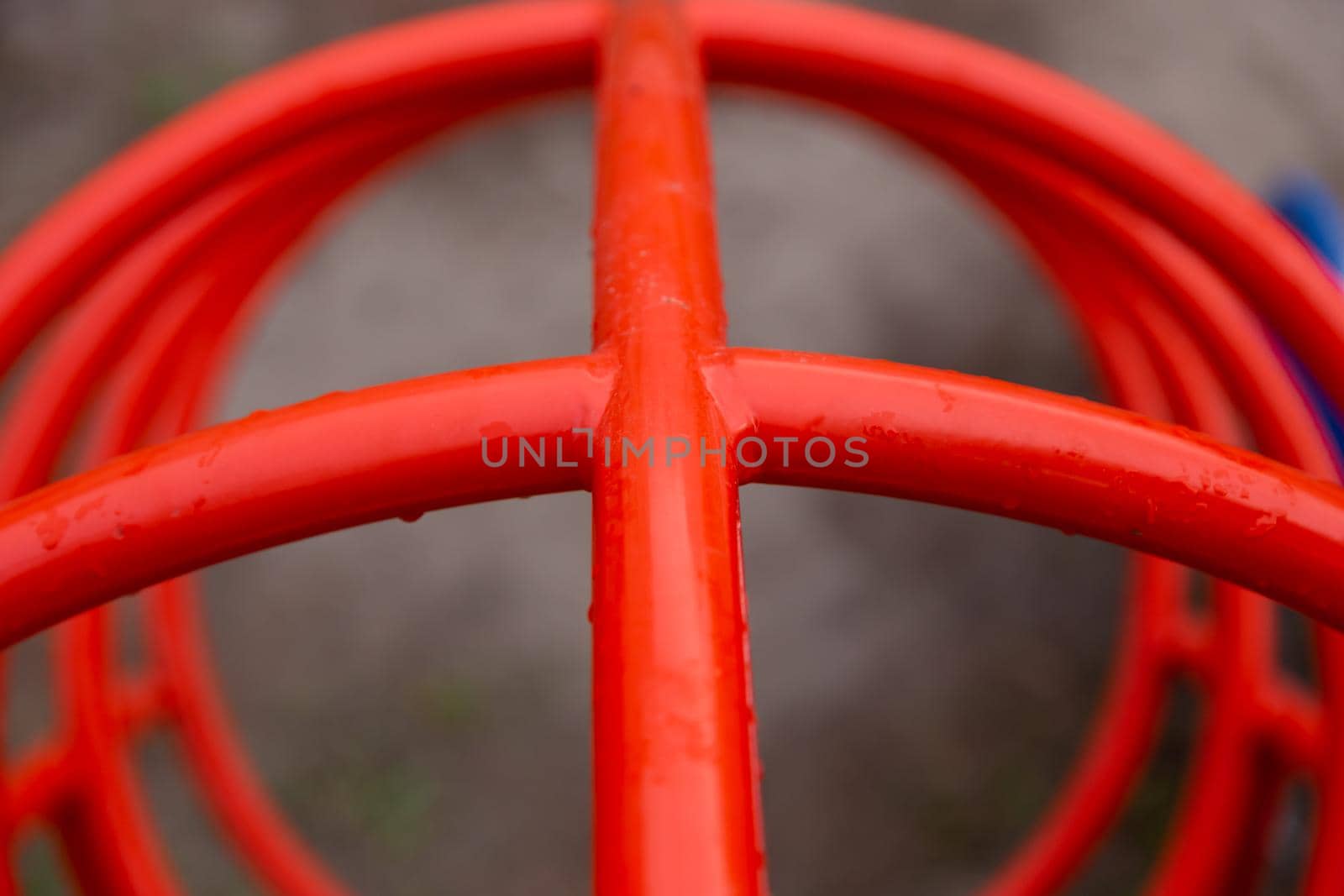 Red pipes in the playground close-up in raindrops.