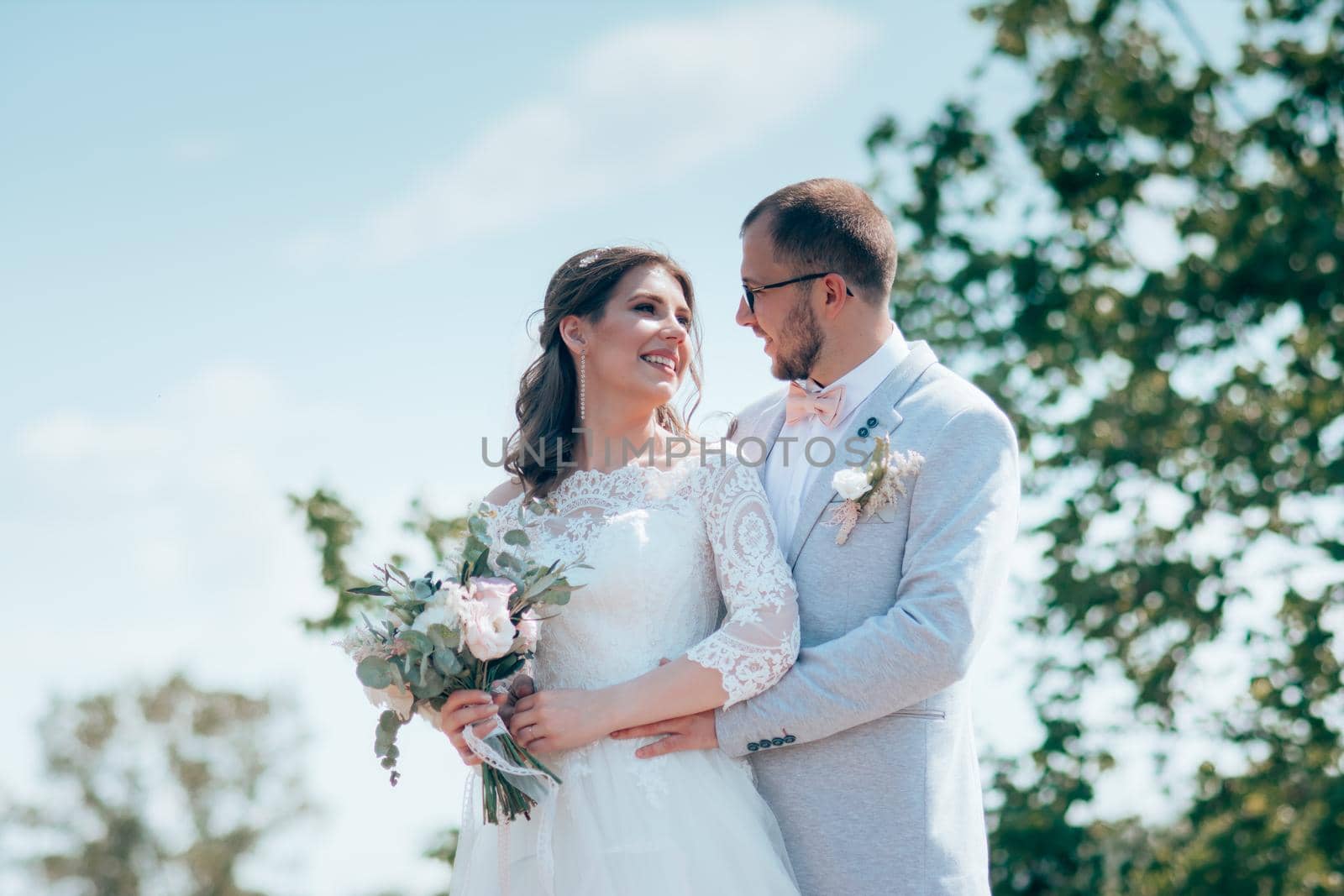 Wedding photo of the bride and groom in a gray-pink color on nature in the forest and rocks. by lunarts