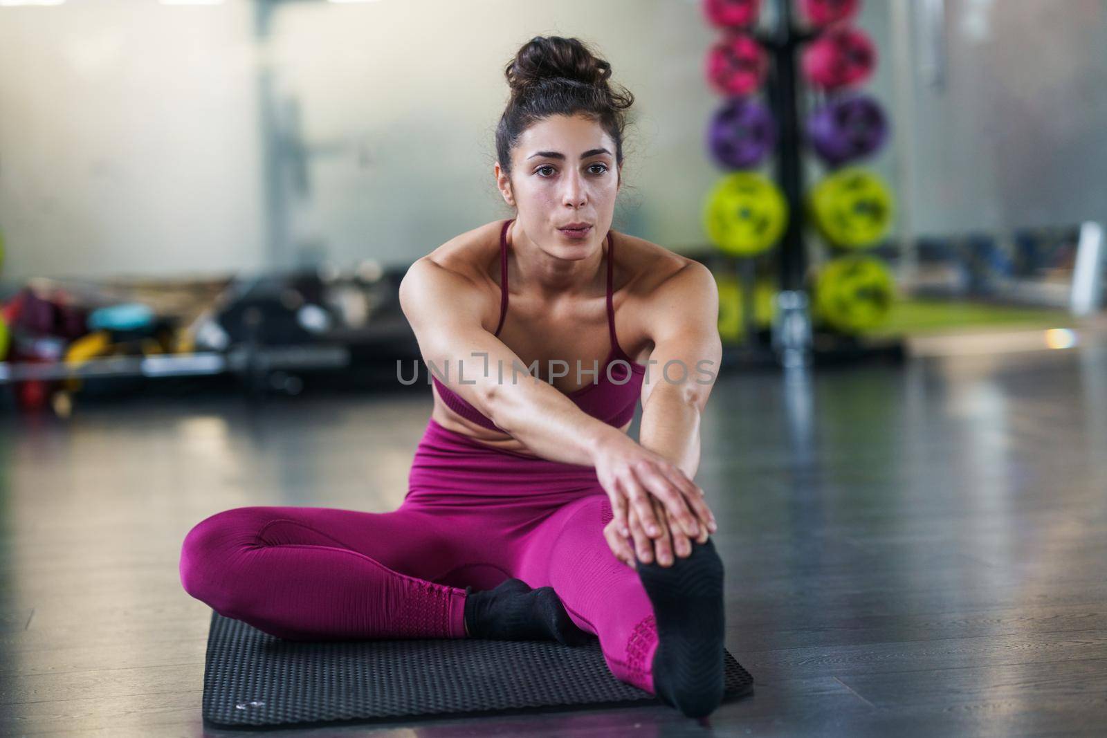 Young woman Doing Stretching Exercises on a yoga mat by javiindy