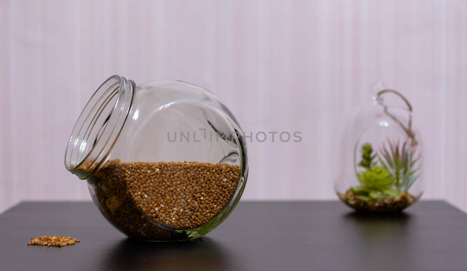 Healthy food buckwheat in a glass jar is on the table. by lunarts