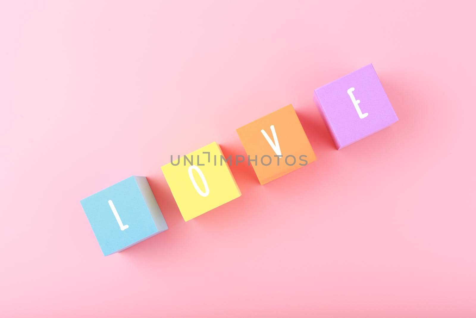 Word love written on colorful toy cubes in diagonal against pink background with copy space by Senorina_Irina